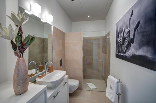 een badkamer met een wastafel, een toilet en een spiegel bij Sky Tower Panorama Apartments in Wrocław