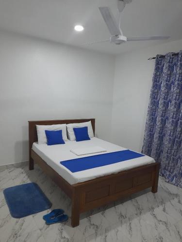a bedroom with a bed with blue pillows at Mwembeni Abode in Bamburi