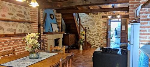 a living room with a table and a brick wall at Apartamento Rural La Tablá in Alles