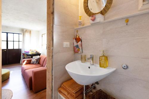 een badkamer met een witte wastafel en een bank bij Les Amis di Peschiera in Peschiera del Garda