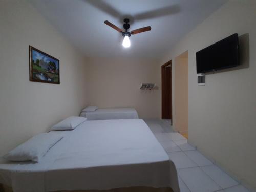 una camera da letto con un letto e un ventilatore a soffitto di Pousada Pena a Aparecida
