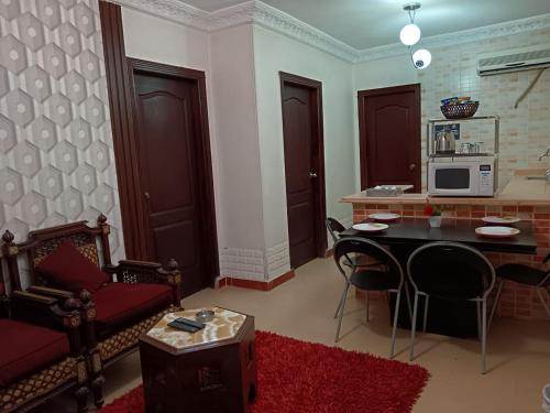 sala de estar con mesa, sillas y microondas en Bonne Vie Hotel, en Seis de Octubre