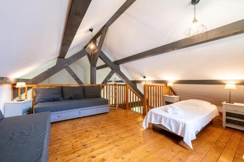 a room with a bed and a couch in it at Chalet Sambuy - Val de Tamié in Faverges