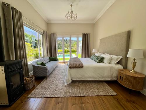Un dormitorio con una cama y una ventana grande en Bergzicht Villa, en Swellendam