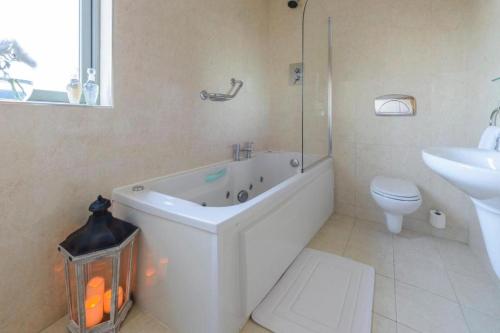 a bathroom with a tub and a toilet and a sink at Park Place Apartments in Killarney