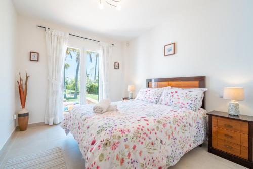 een witte slaapkamer met een bed en een raam bij Cala Egos Villa - S'Estel in Cala d´Or