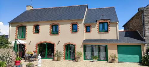 a large house with green doors and windows at Chambres D'hôtes Mongarny Cancale in Cancale