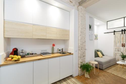 eine Küche mit weißen Schränken und ein Wohnzimmer in der Unterkunft Galteo Almendra in Ronda