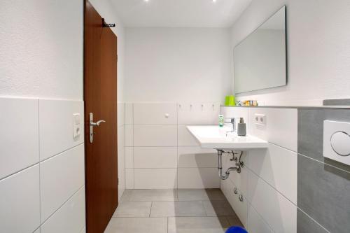 a white bathroom with a sink and a mirror at Haus Anita in Menzenschwand