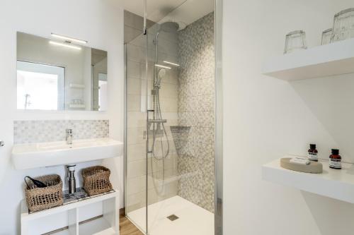 un bagno con lavandino e doccia di Kerwall - Maison d'hôtes a Malville