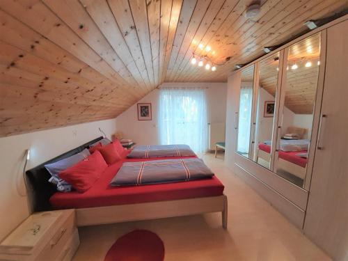 a bedroom with a red bed and a wooden ceiling at Ferienwohnung Bauchert in Schwäbisch Gmünd