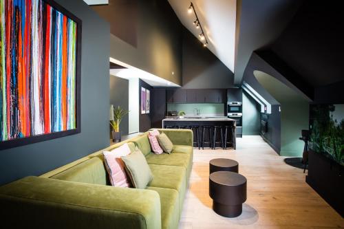 a living room with a couch and a kitchen at Urban Jungle by Domu Stays in Manchester