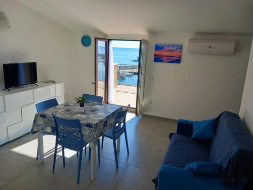 a living room with a table and a blue couch at La Perla del Mare in Pisciotta