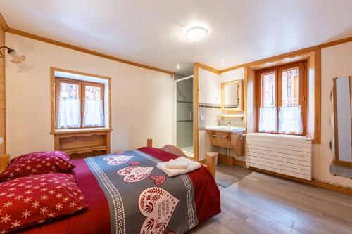 ein Schlafzimmer mit einem Bett und ein Badezimmer mit einem Waschbecken in der Unterkunft Chalet De Charme à la Montagne in La Lechere