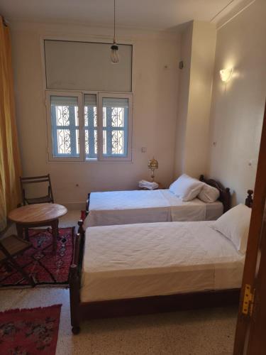 En eller flere senge i et værelse på maison de tourisme el amal