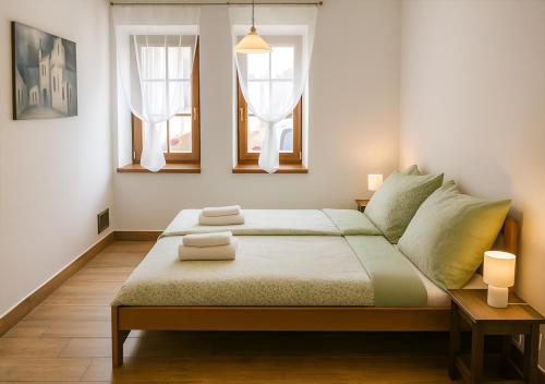 Un dormitorio con una cama grande con dos ventanas. en Prázdninový dům - Bechyně, en Bechyně