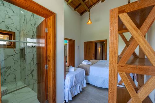 a bedroom with two beds and a glass door at Village das Estações in Marau