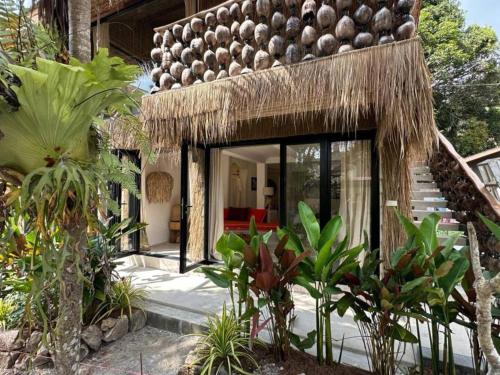 a house with a straw roof and some plants at Happy Coco Monkey - Cozy Studio By Sp Villa in Koh Phangan