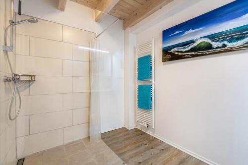 a bathroom with a shower and a painting on the wall at Ferienwohnung Hof Krakebüll in Humptrup