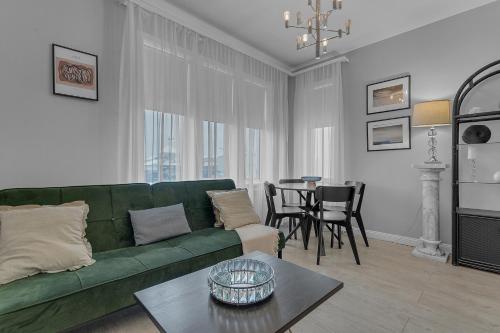 a living room with a green couch and a table at Castle Inn Apartments - Downtown Keflavík in Keflavík
