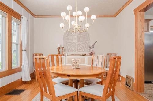 a dining room with a wooden table and a chandelier at 3 Bedroom Family Home - University of Oshkosh in Oshkosh