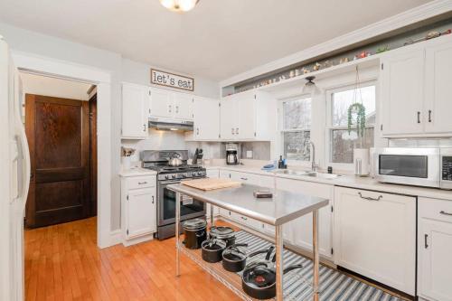 オシュコシュにあるCharacter Family Home - 3 bedroom 2 bathの白いキャビネットとテーブル付きのキッチンが備わります。