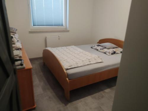a small bedroom with a bed and a window at Mieszkanie do wynajęcia in Ostróda