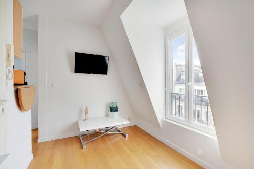 una stanza bianca con un tavolo bianco e una finestra di INVALIDES - TOUR EIFFEL a Parigi