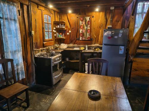 a kitchen with a refrigerator and a table in a cabin at Cabaña Punta Mogotes in Mar del Plata