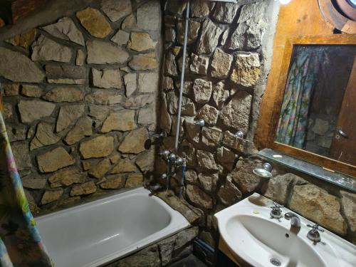 a stone bathroom with a bath tub and a sink at Cabaña Punta Mogotes in Mar del Plata