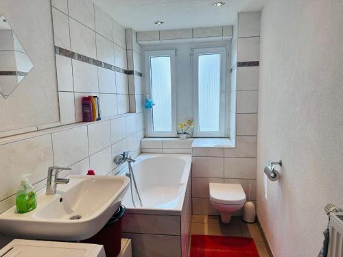a bathroom with a sink and a tub and a toilet at Gasthaus Pavillon in Dresden