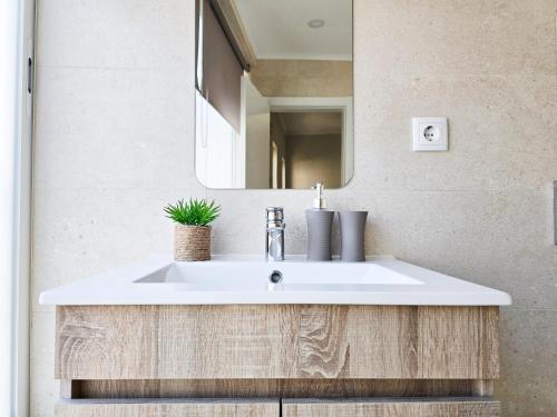 a bathroom with a white sink and a mirror at Casa Safia - Beach & Center 200m, AC, WiFi in Carvoeiro