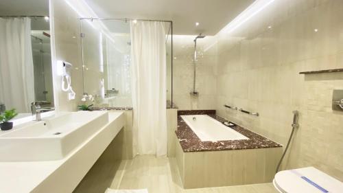 a bathroom with a large sink and a tub at Best Western Plus Multan in Multan