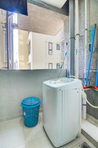 a bathroom with a toilet and a blue trash can at VibeStayZ Kedar Hinjewadi in Hinjewadi