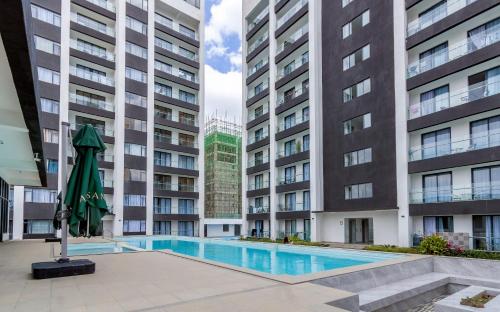 an apartment complex with a swimming pool and two tall buildings at Acquila Crest by JKIA in Nairobi