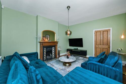 un salon avec un canapé bleu et une cheminée dans l'établissement Convenient 3-Bed Near Bingham Station & Town Centre, à Bingham