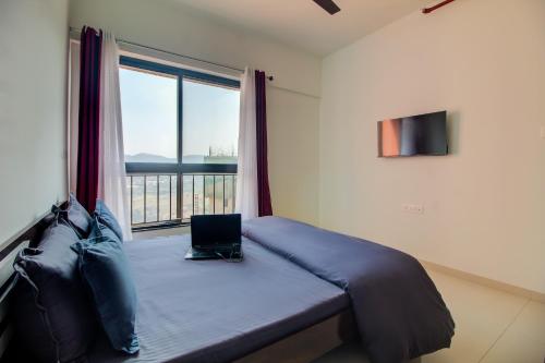 a bedroom with a bed with a laptop on it at VibeStayZ Kedar Hinjewadi in Hinjewadi