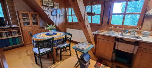Una cocina con una mesa y sillas y un fregadero. en Ferienwohnung Vogelnest, en Betzenstein