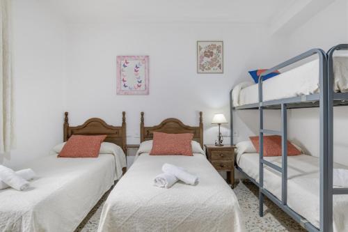 1 Schlafzimmer mit 2 Etagenbetten und 1 Etagenbett in der Unterkunft Casa Grande en el Centro de Conil in Conil de la Frontera
