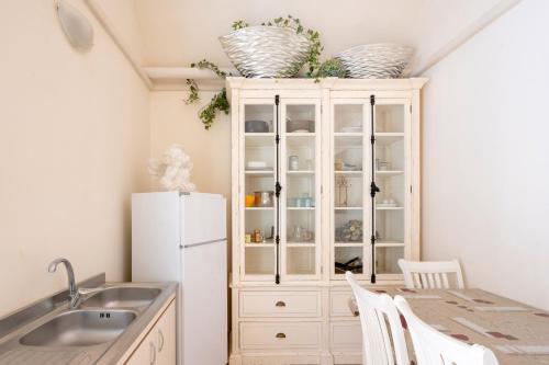 une cuisine avec un réfrigérateur blanc et une table dans l'établissement Palazzo Costantini, à San Donato di Lecce