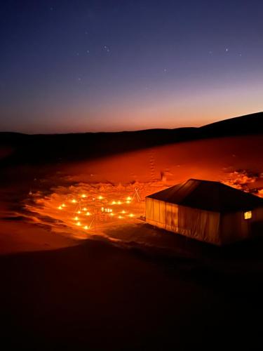 a view of a tent at night with lights at Across Sahara in Bou Nou