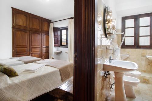 a bathroom with a bed and a sink in a room at Casa do Adro do Soajo in Soajo