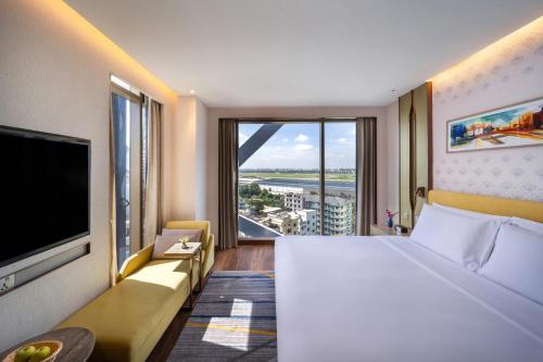 a hotel room with a large bed and a large window at Hyatt Place Dhaka Uttara in Dhaka