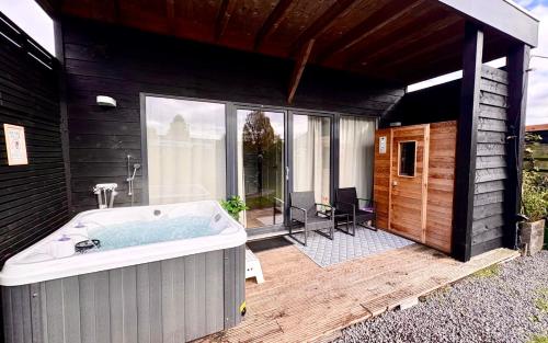 a large bath tub sitting outside of a house at Family house with garden & jacuzzi & sauna near Amsterdam in Vijfhuizen