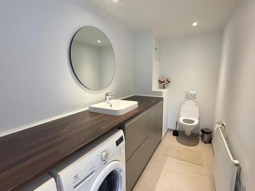 a bathroom with a sink and a washing machine at Large central townhouse, only 500m from Horsens city center in Horsens