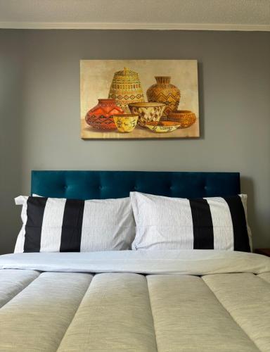 um quarto com uma cama e uma pintura na parede em Teatinos Departamentos STGO em Santiago