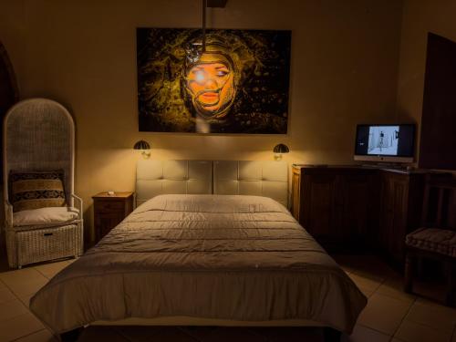 a bedroom with a bed with a painting of a mask at Poolhouse Oasi del Lupo in Subbiano