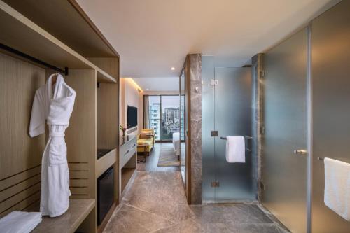 a bathroom with a shower and a robe at Hyatt Place Dhaka Uttara in Dhaka