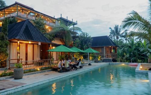 people sitting by the pool at a resort at Mina Baturiti Hotel & Resto in Patjung