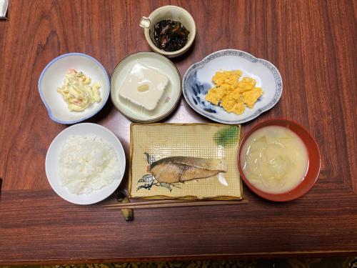a wooden table with plates of food on it at くりのやかた in Kunisaki